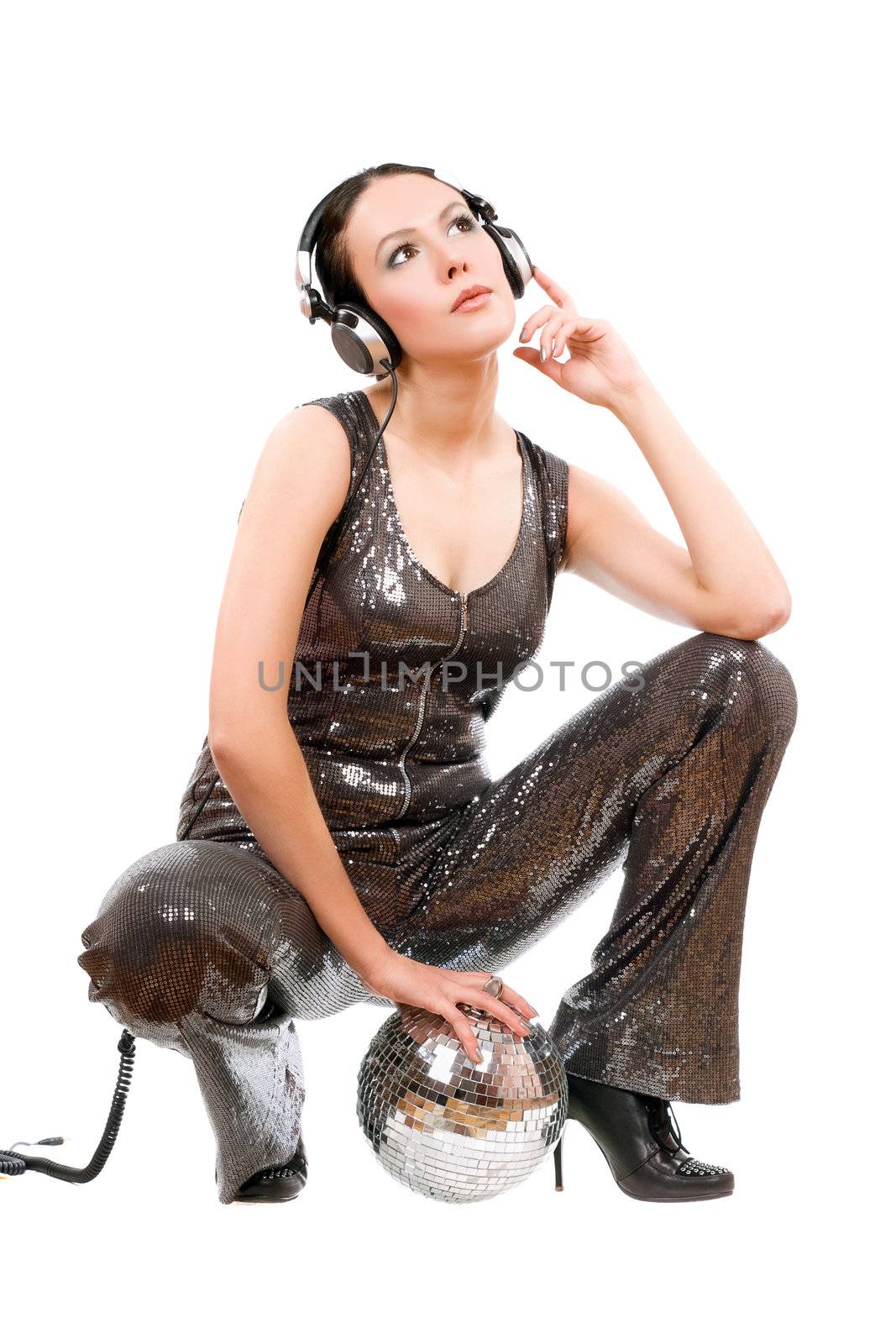Beautiful young brunette in headphones with a mirror ball. Isolated