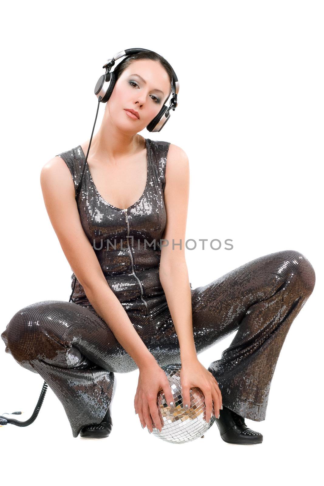 Beautiful young brunette in headphones with a mirror ball. Isolated on white