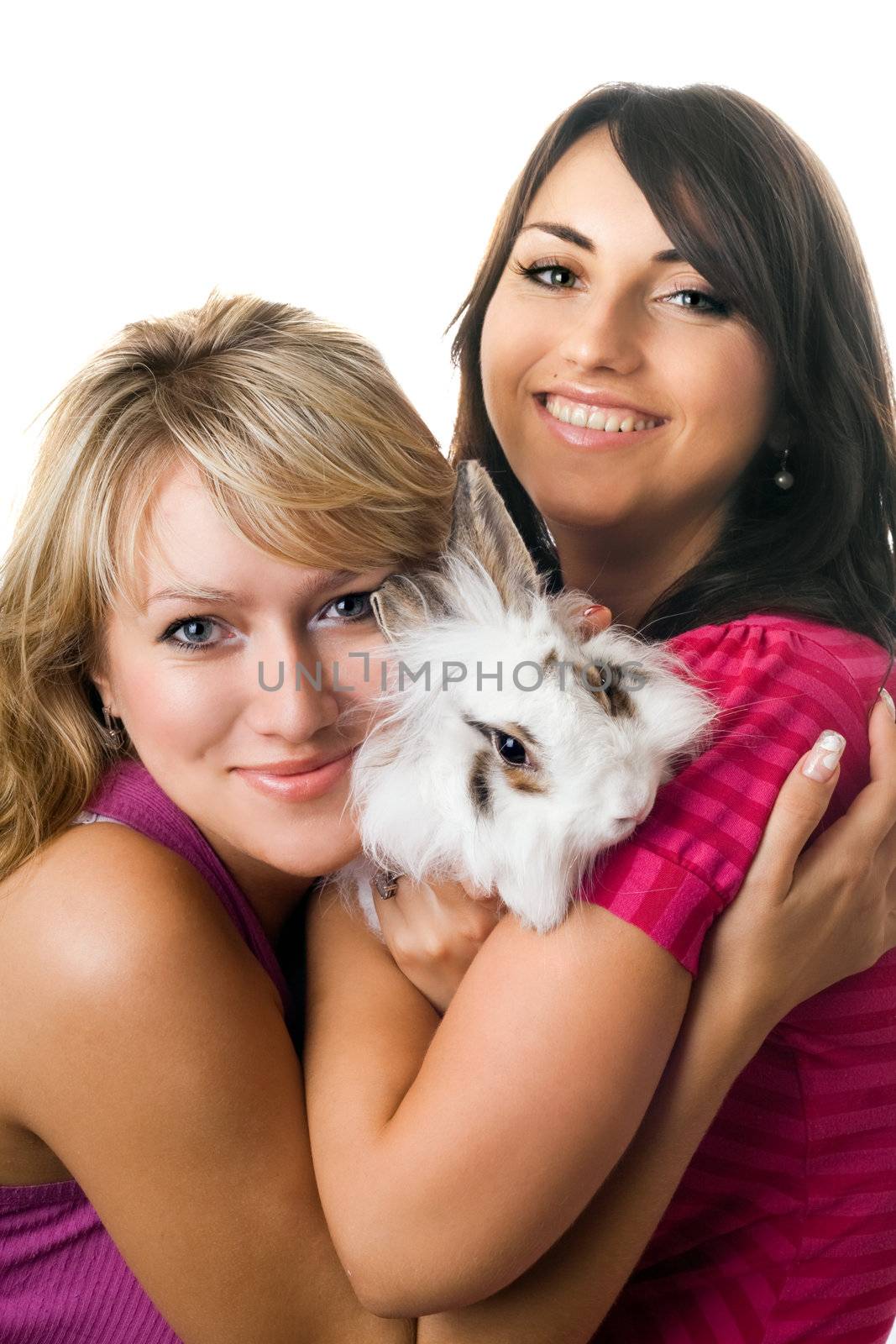 Two young women posing with little rabbit. Isolated on white