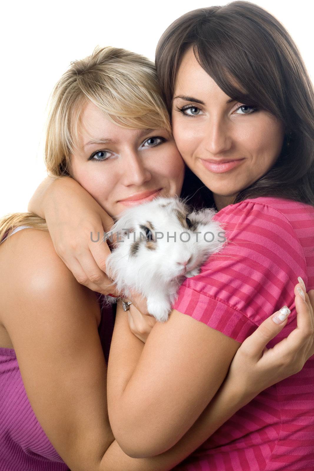 Two young women embracing little rabbit. Isolated on white