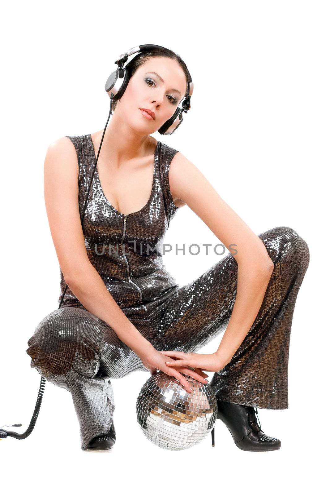 Attractive young brunette in headphones with a mirror ball. Isolated