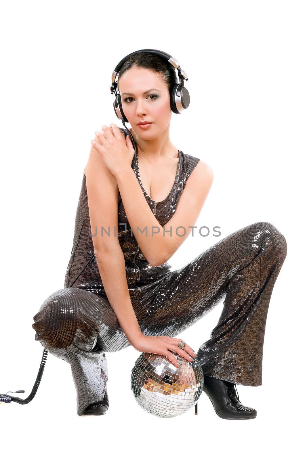 Sexy young brunette in headphones with a mirror ball. Isolated