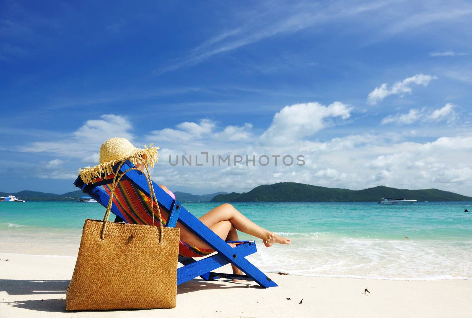 Girl on a tropical beach in chaise lounge