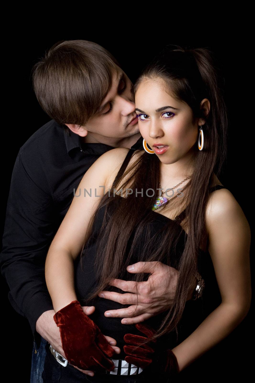 Portrait of young playful couple. Isolated on black