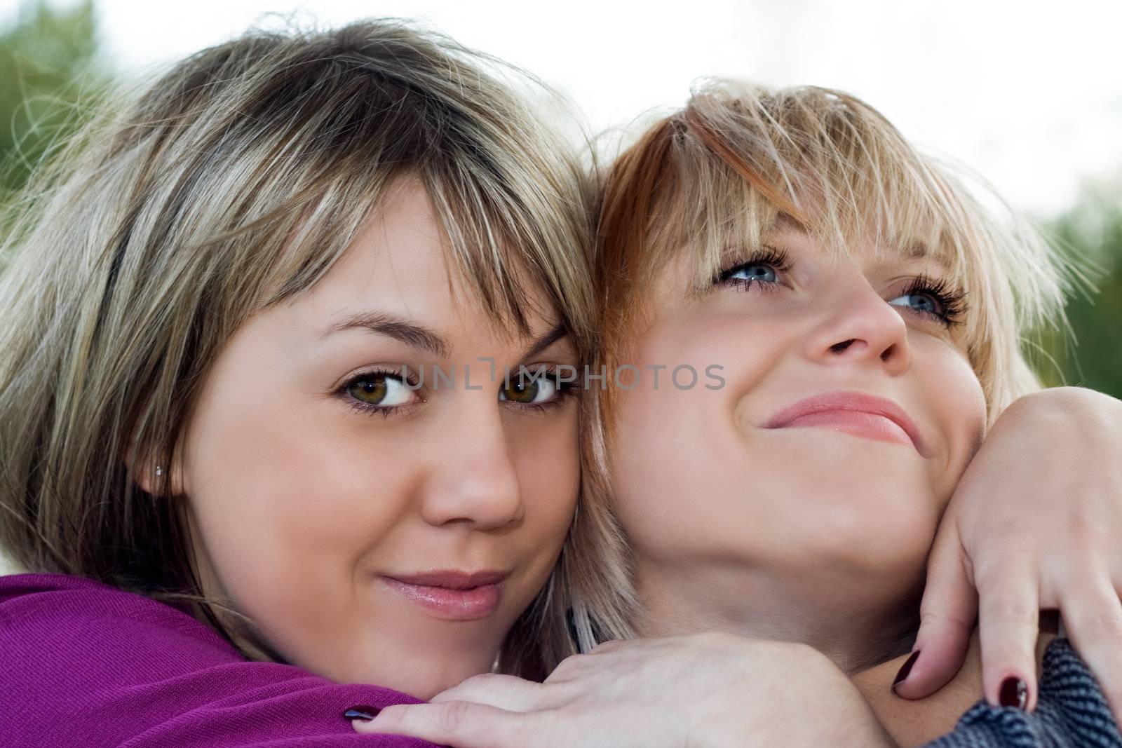 Portrait of the two smiling young women outdoors by acidgrey