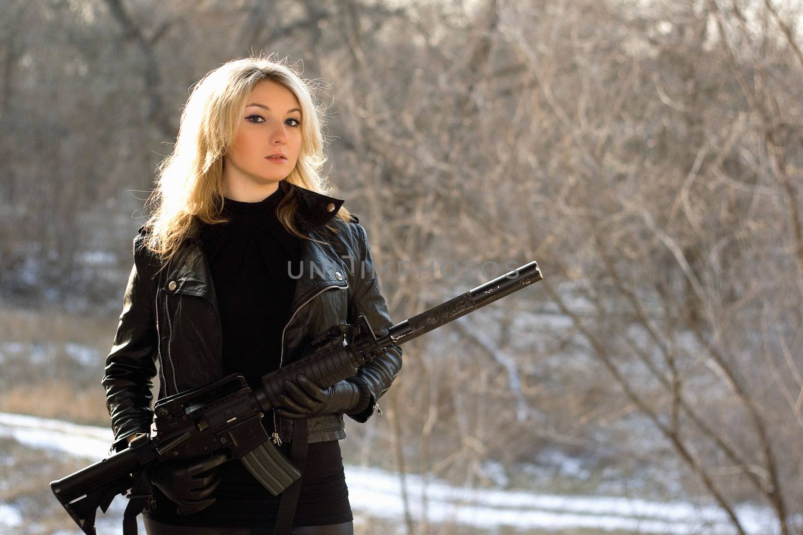 Portrait of attractive young blonde with a gun