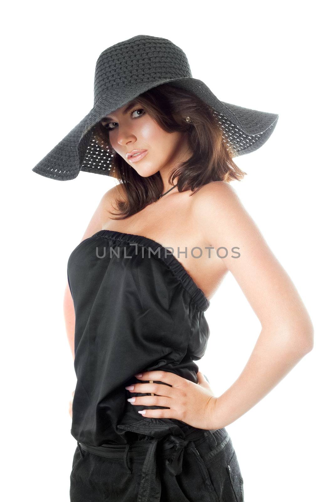 Young woman posing in black hat and dress. Isolated on white