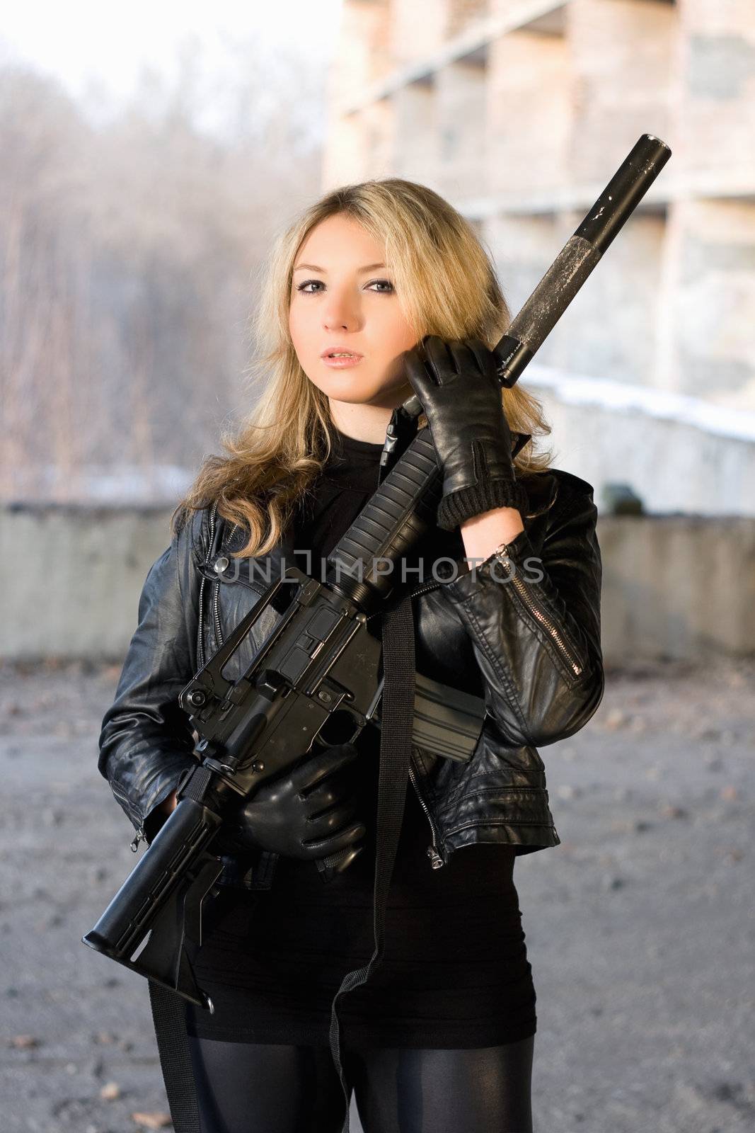 Hot woman in leather jacket holding a rifle