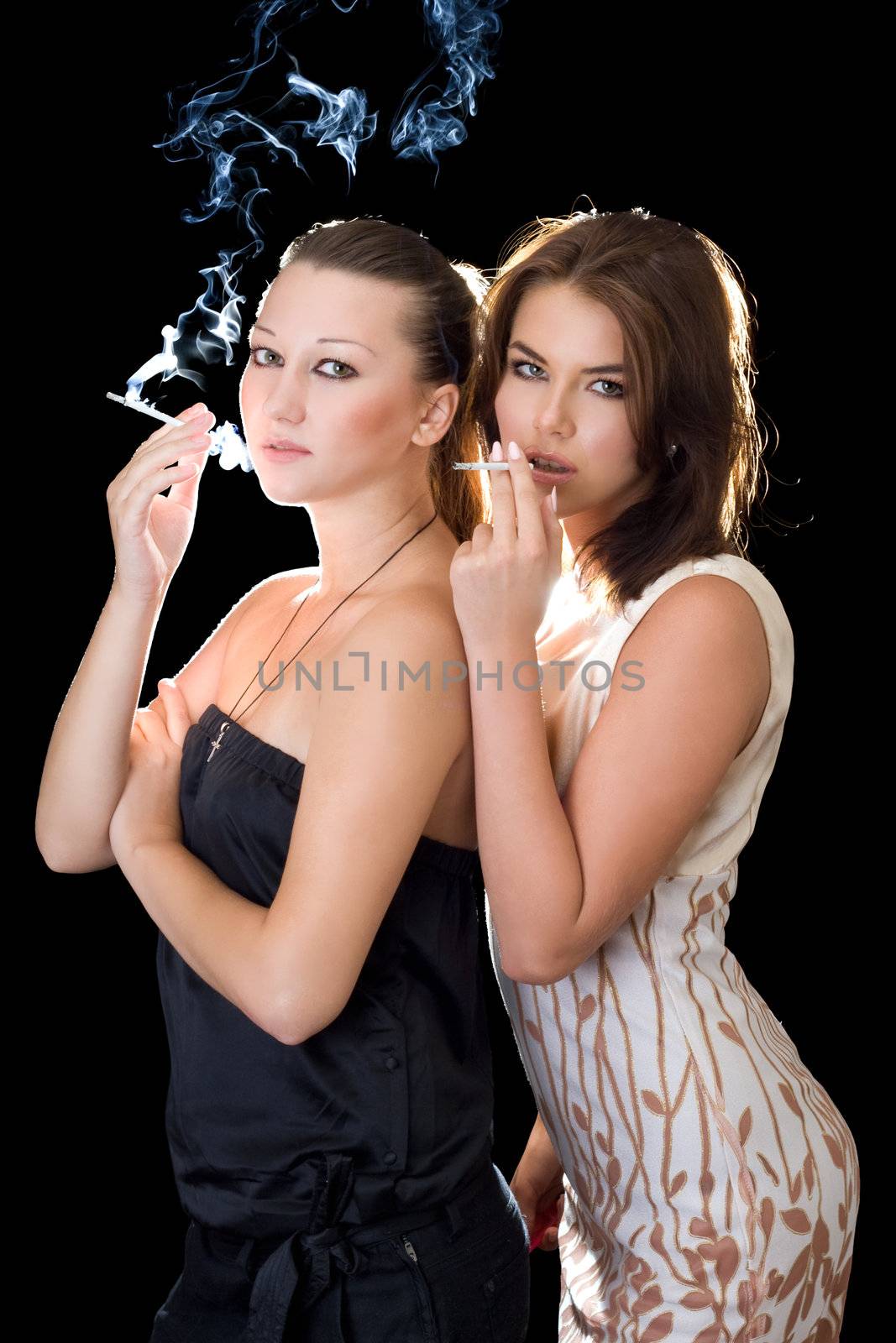 Two girlfriends with cigarettes. Isolated on black