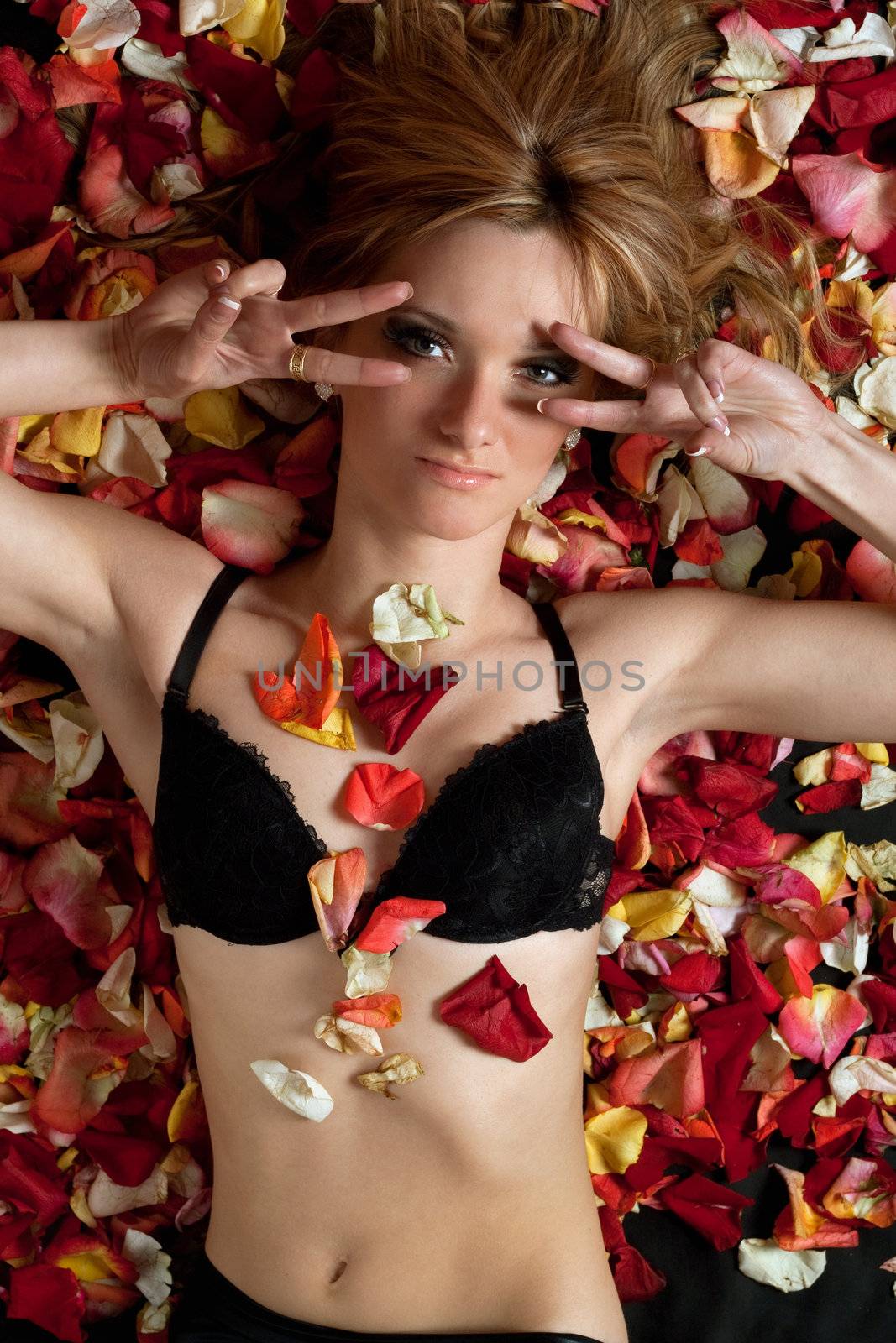 Portrait of beautiful young woman lying in rose petals