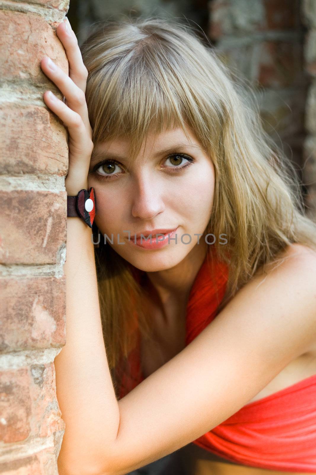 Portrait of young pretty woman near the brick wall