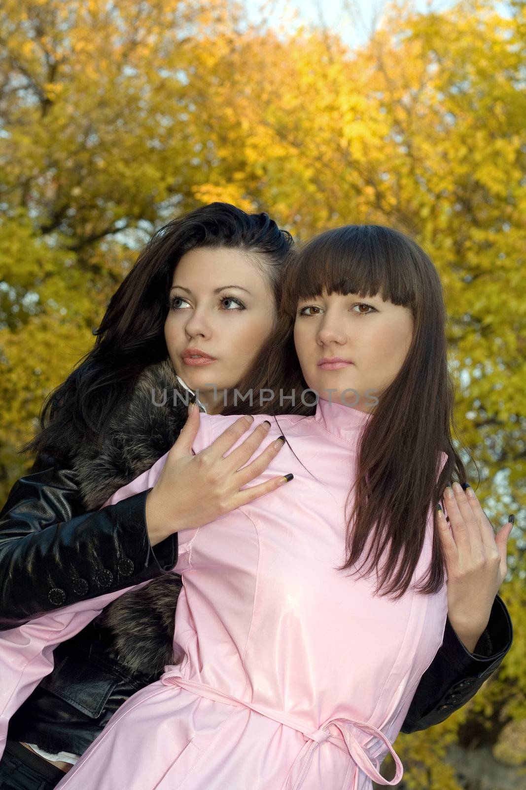 Two beauty young women outdoors in the autumn