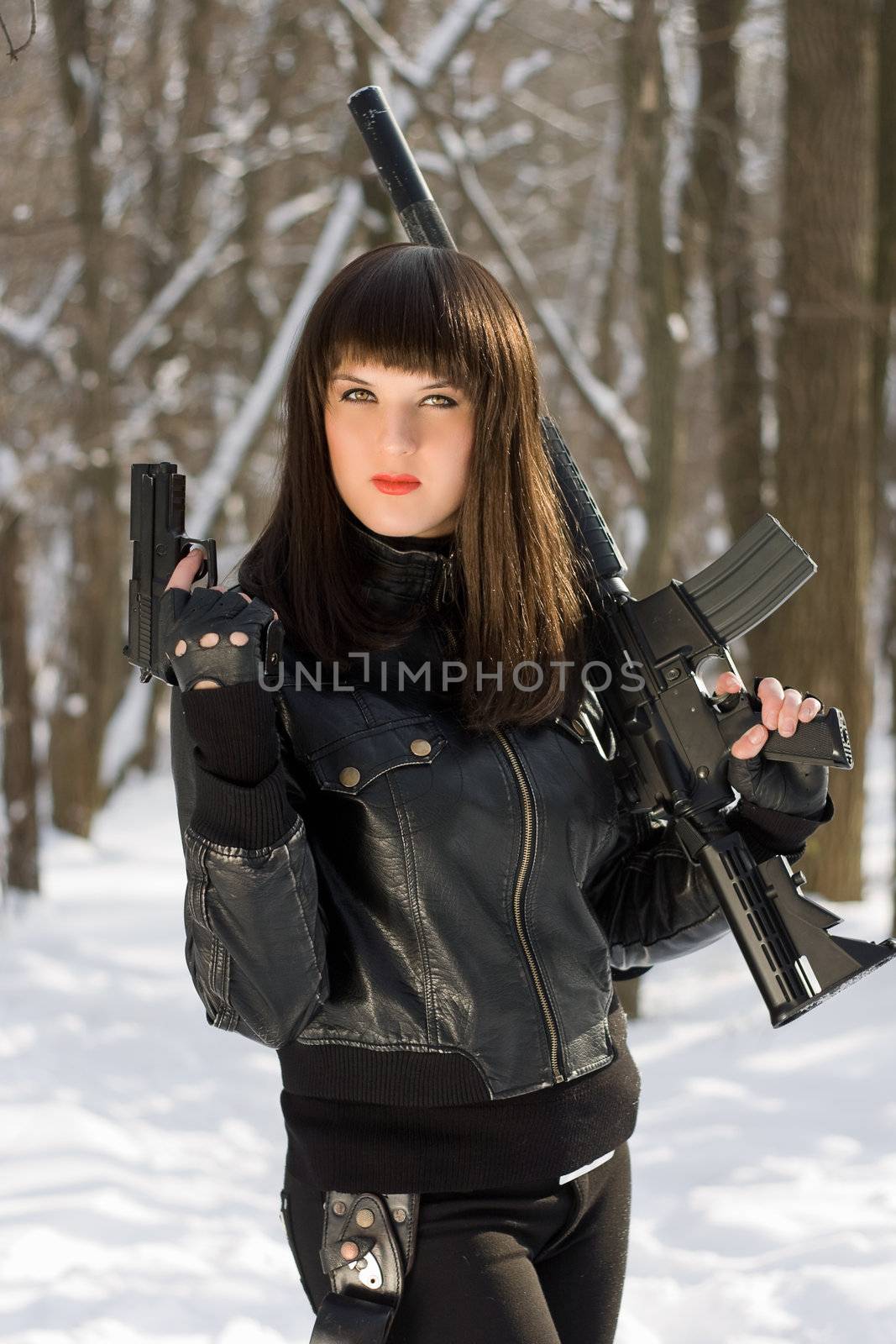 Portrait of attractive young woman with weapon in their hands