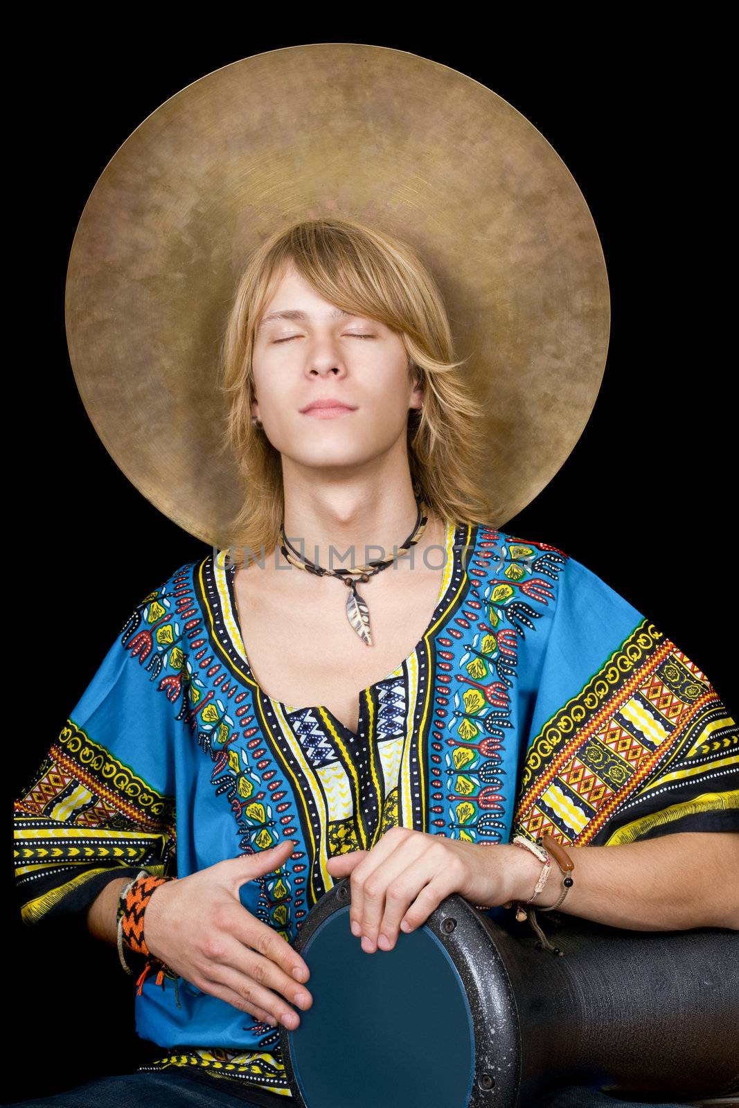 The young man plays a drum over black