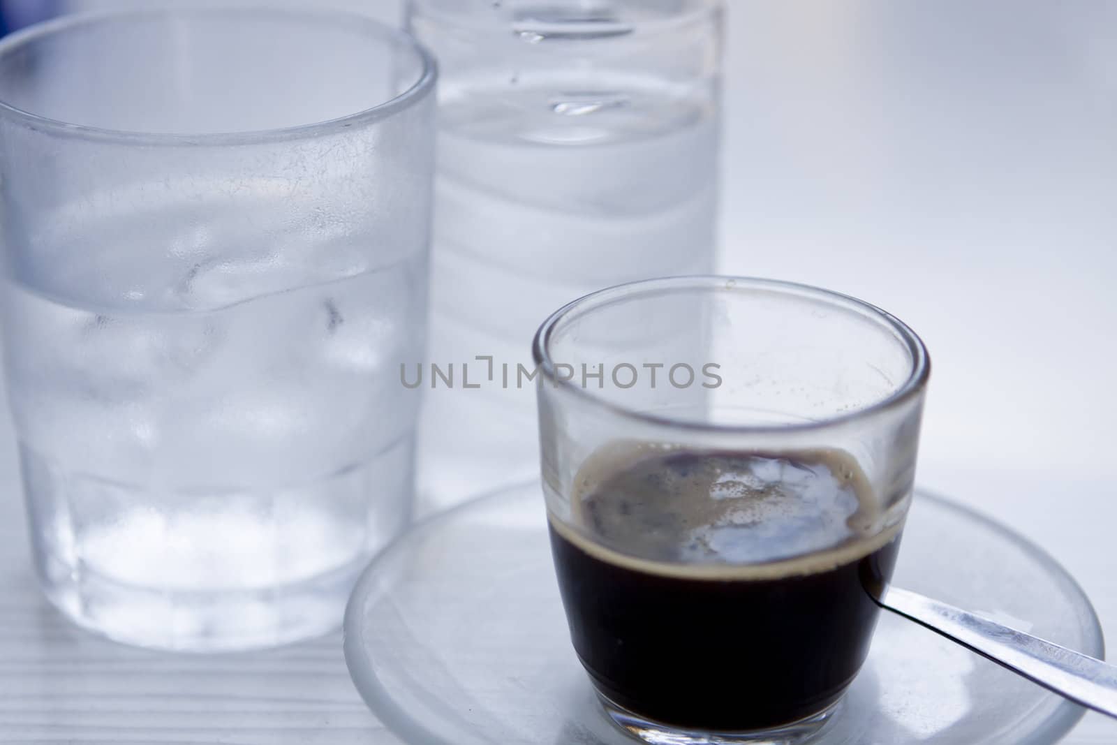 hot aromatic espresso cup and cold water in glass by juniart