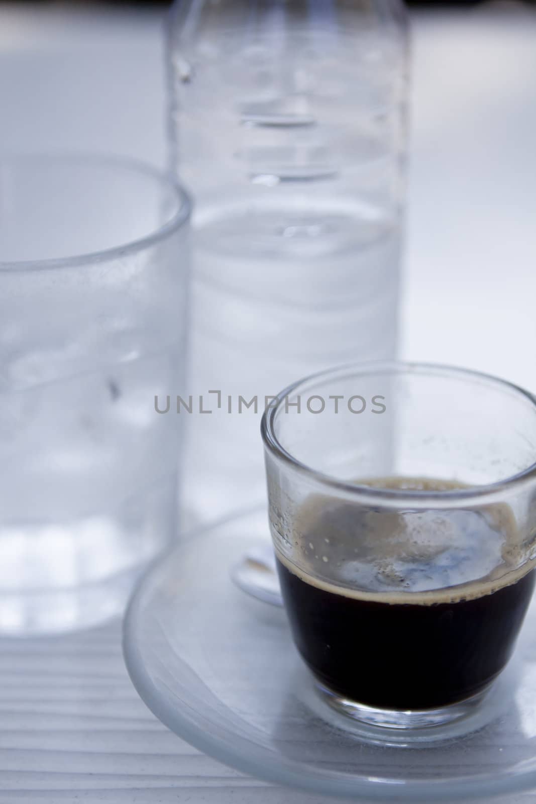 hot aromatic espresso cup and cold water in glass in a caf� in summer outdoor
