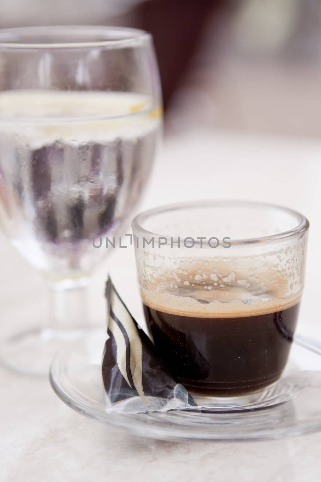 hot aromatic espresso cup and cold water in glass in a caf� in summer outdoor