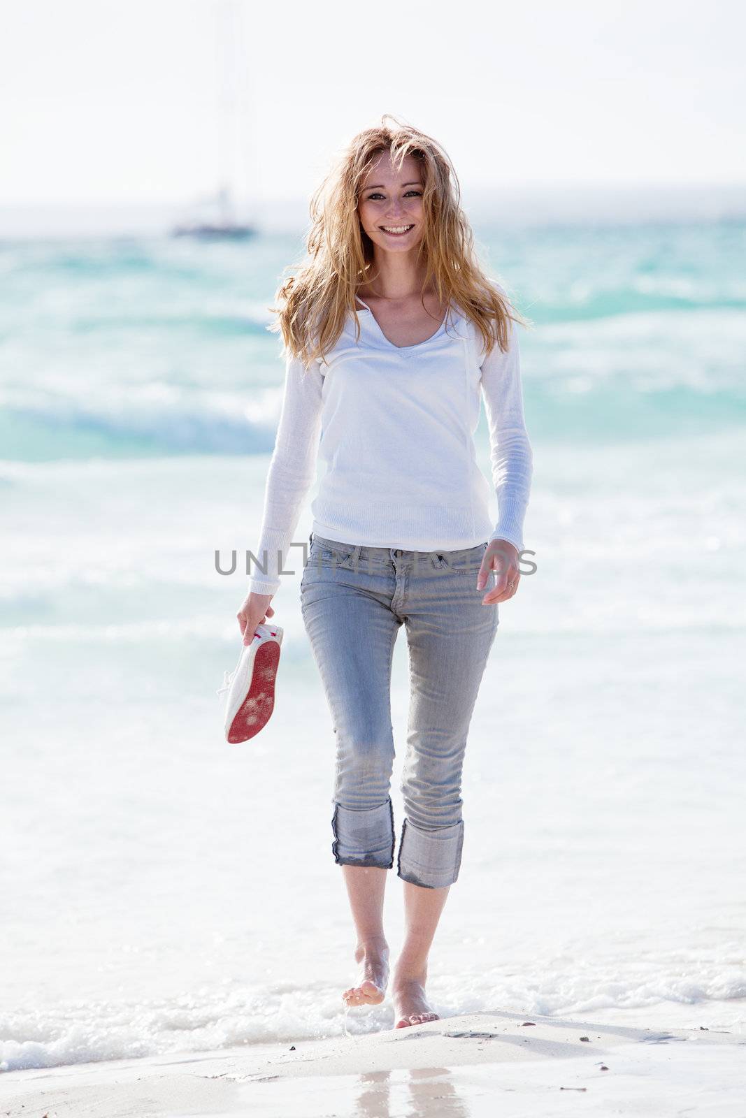 beautiful young woman walking on beach in summer vacation relaxing