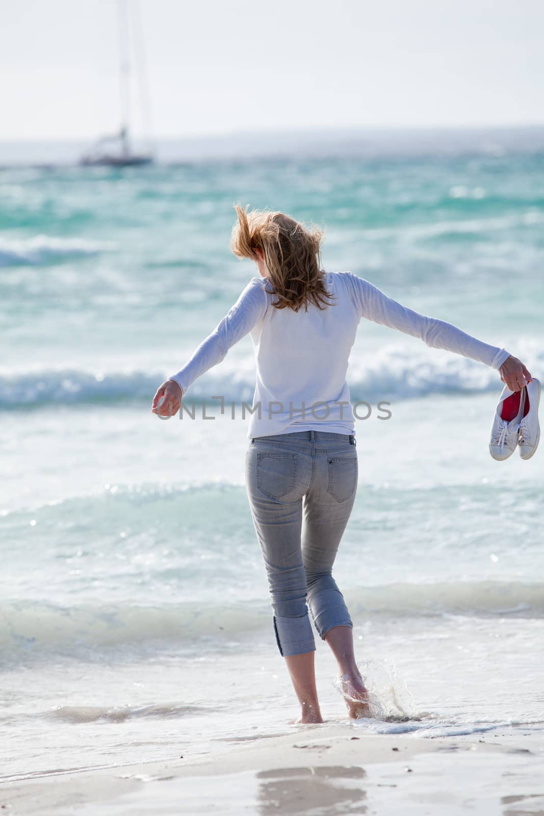 beautiful young woman walking on beach in summer vacation relaxing