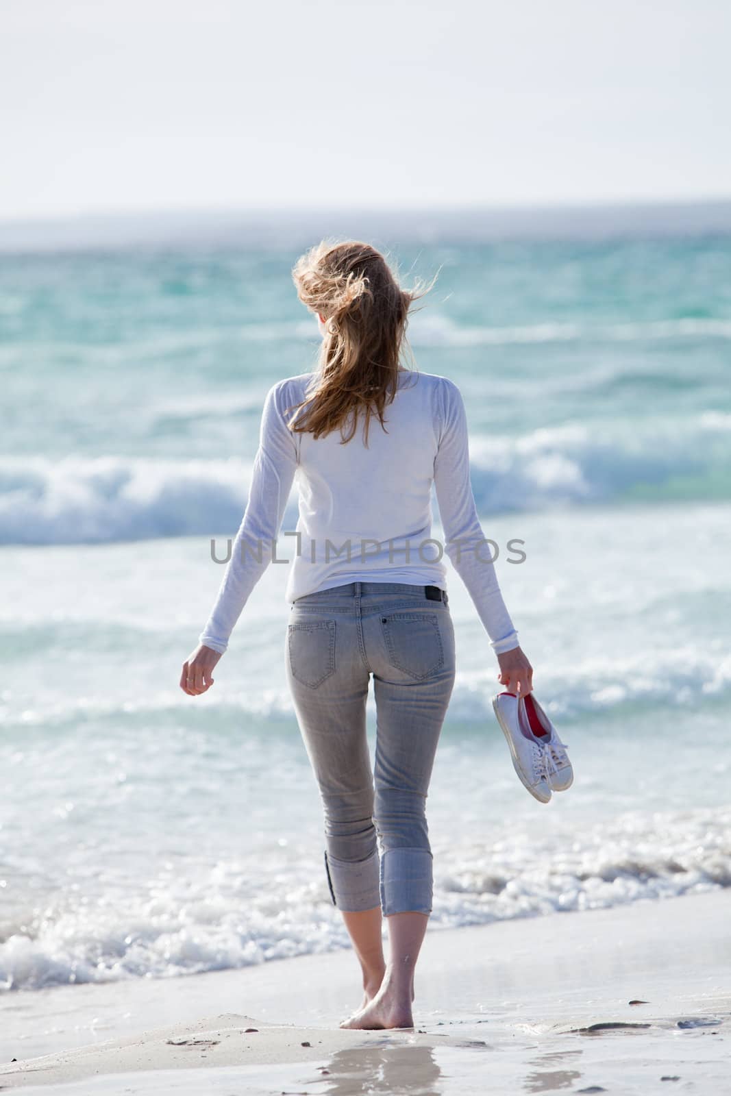beautiful young woman walking on beach in summer vacation relaxing