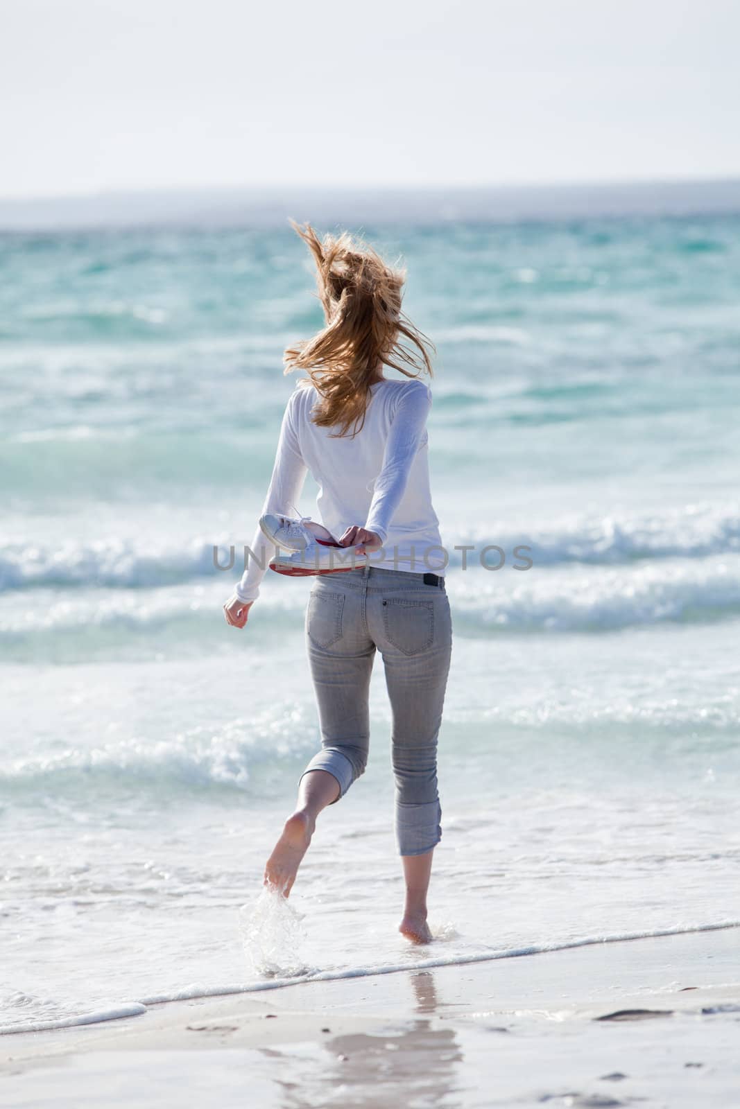 beautiful young woman walking on beach in summer vacation relaxing