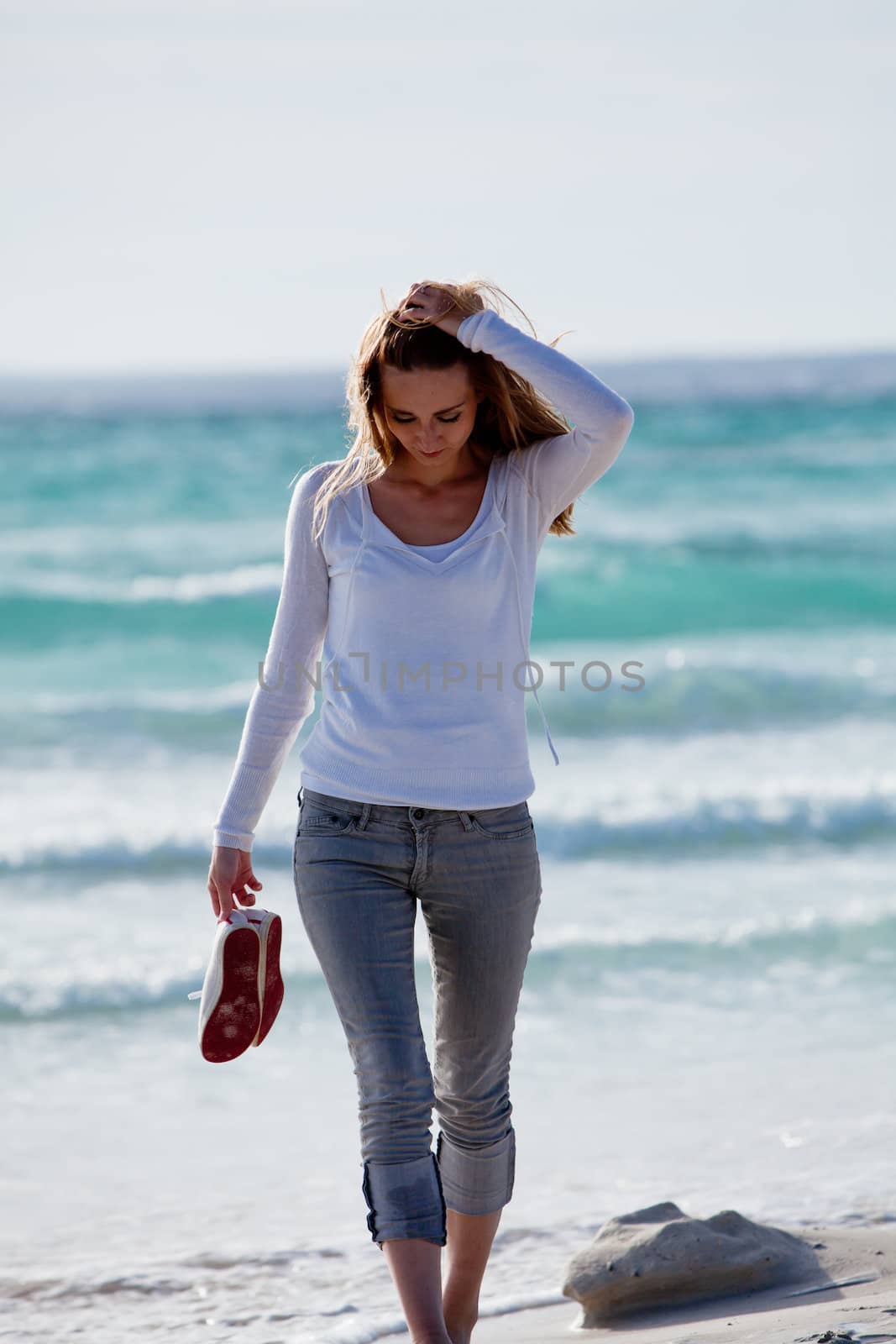 beautiful young woman walking on beach in summer vacation relaxing