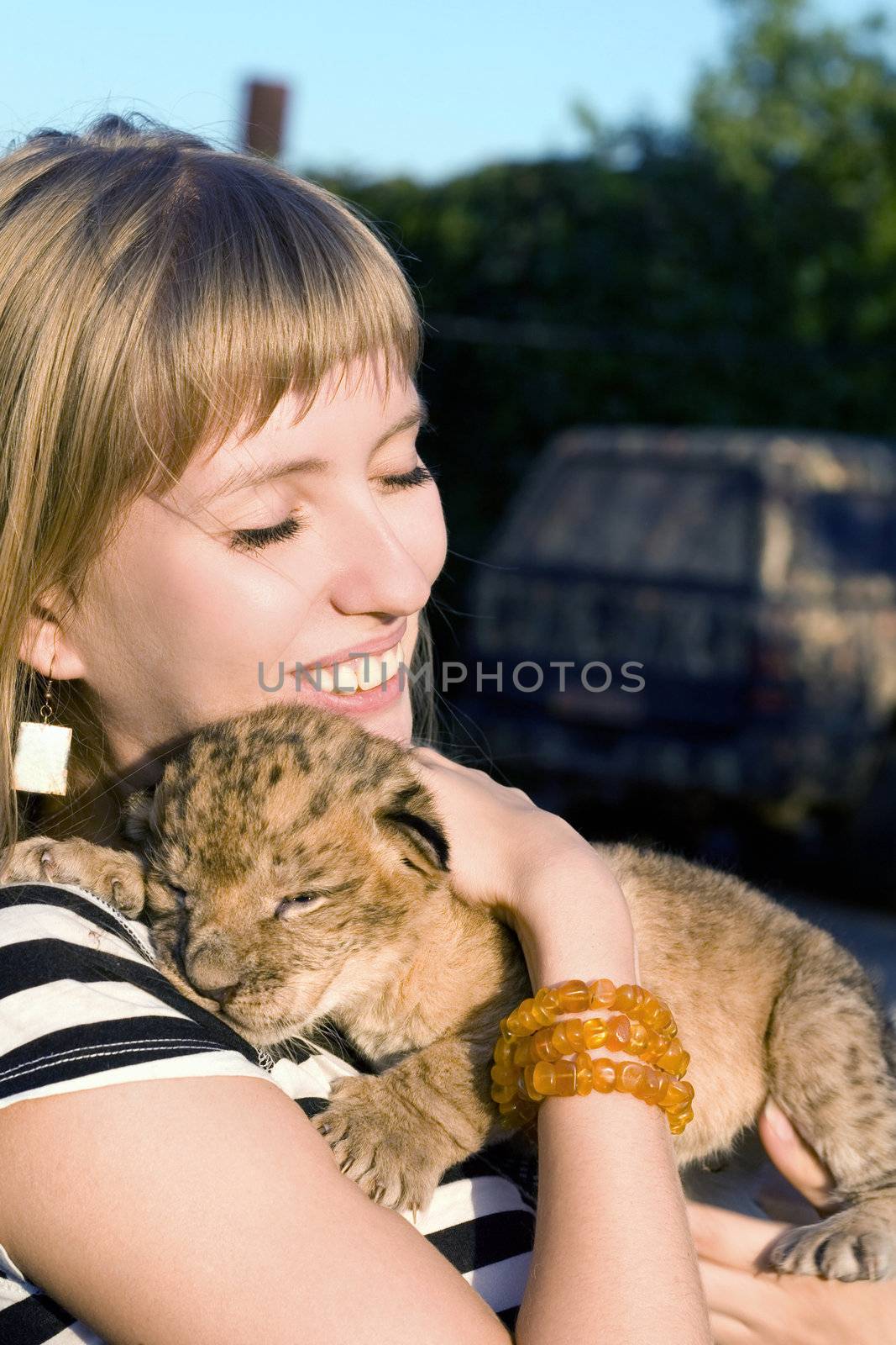 Portrait of young woman playing with lion cub