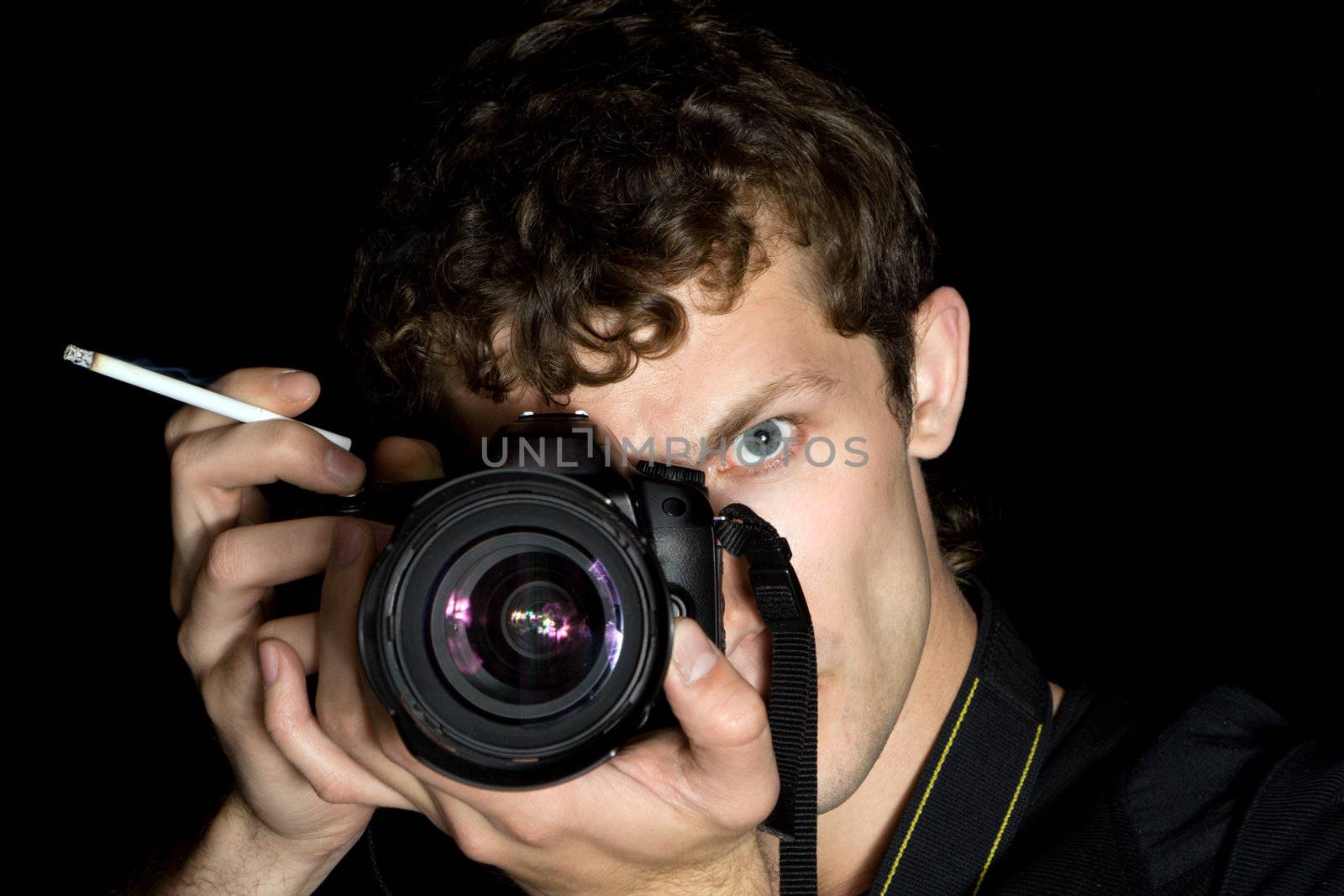 The young man - photographer behind work. Isolated on a black background 3