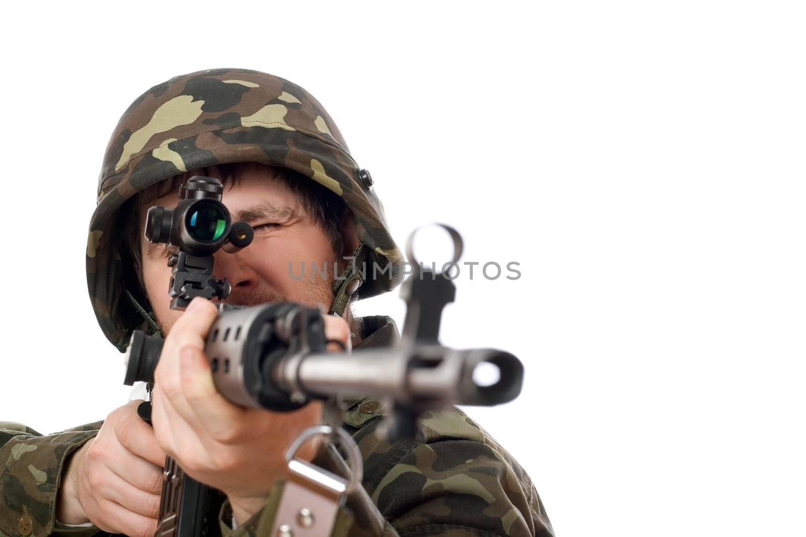Soldier aiming a rifle in studio. Isolated