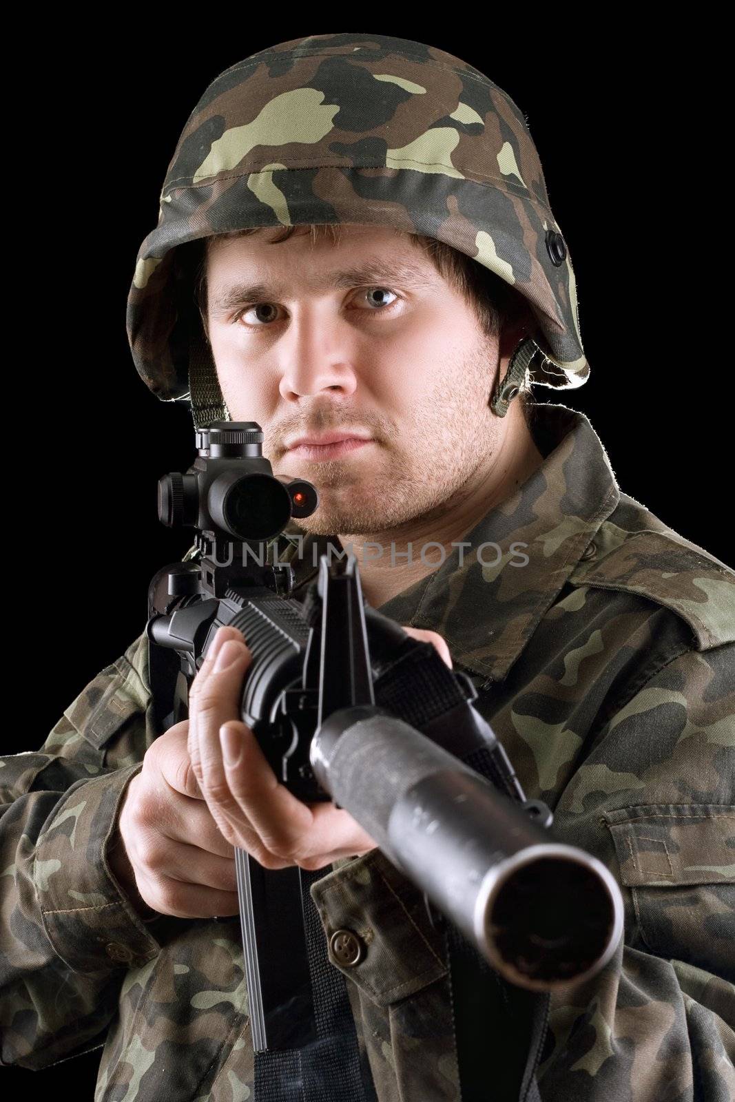 Soldier holding a gun in studio. Isolated