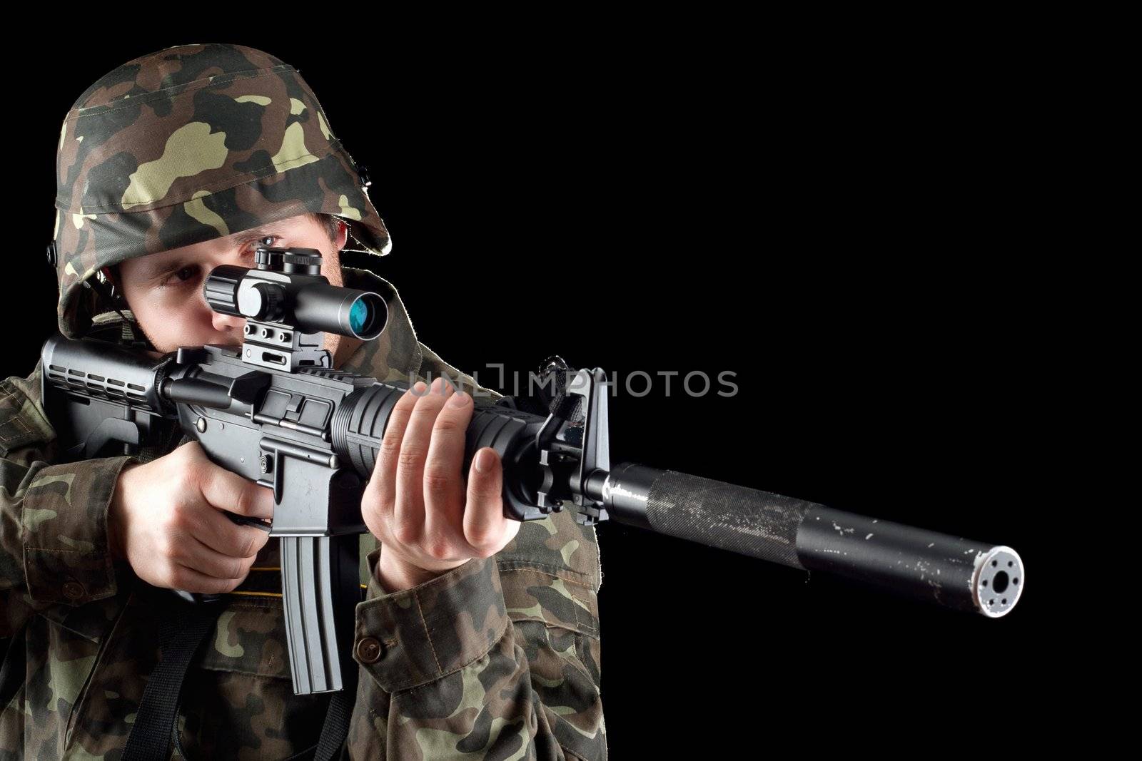 Armed man taking aim in studio. Closeup