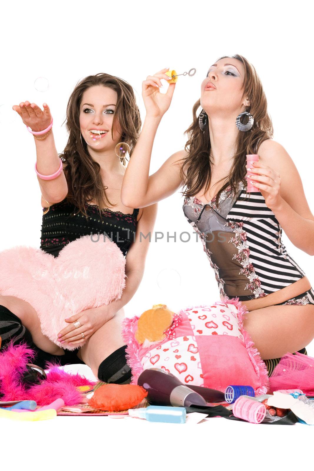 Two happy girls blow bubbles. Isolated on white