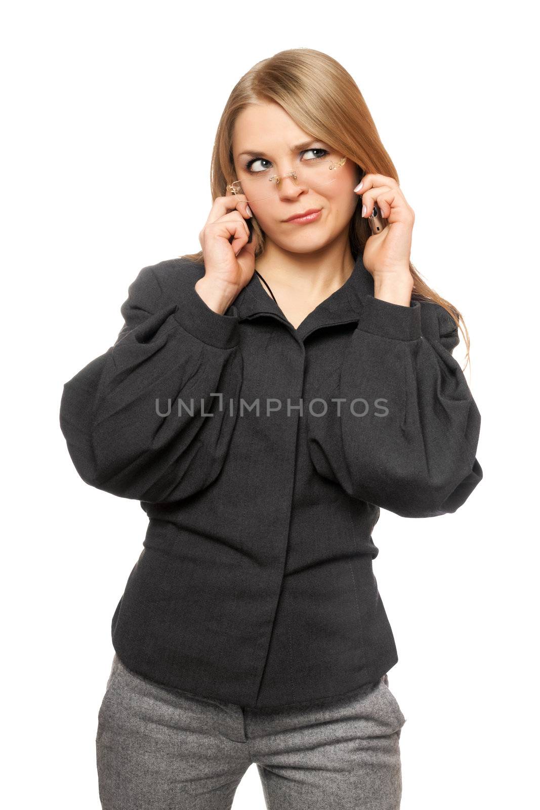 Discontented young blonde in a gray business suit with two phones