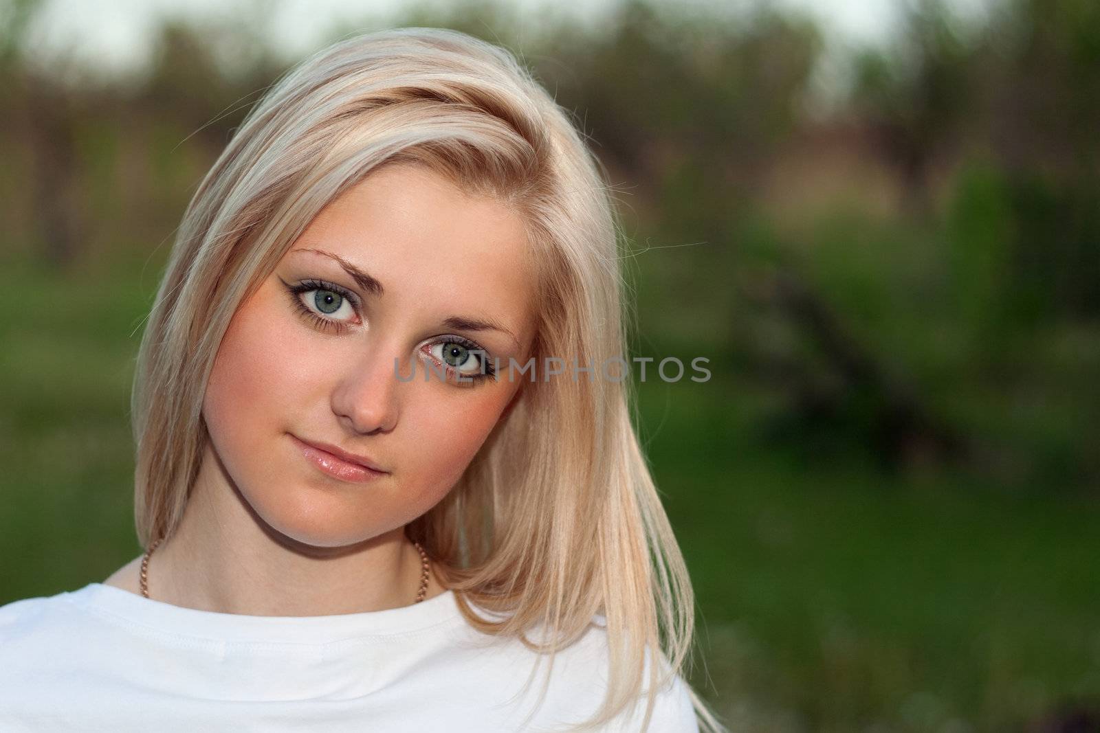 Closeup portrait of young lovely blonde outdoors