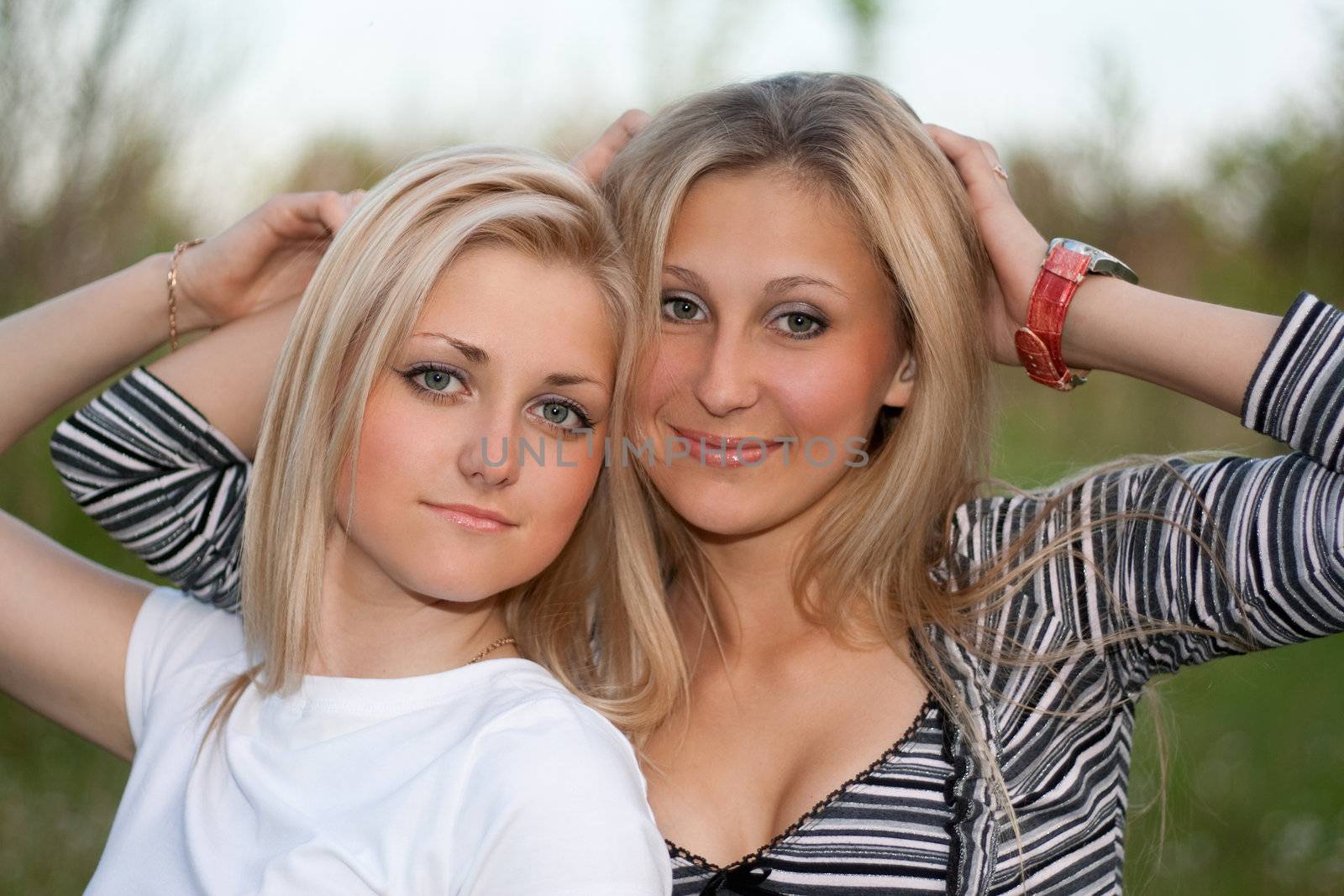 Closeup portrait of two attractive young women outdoors
