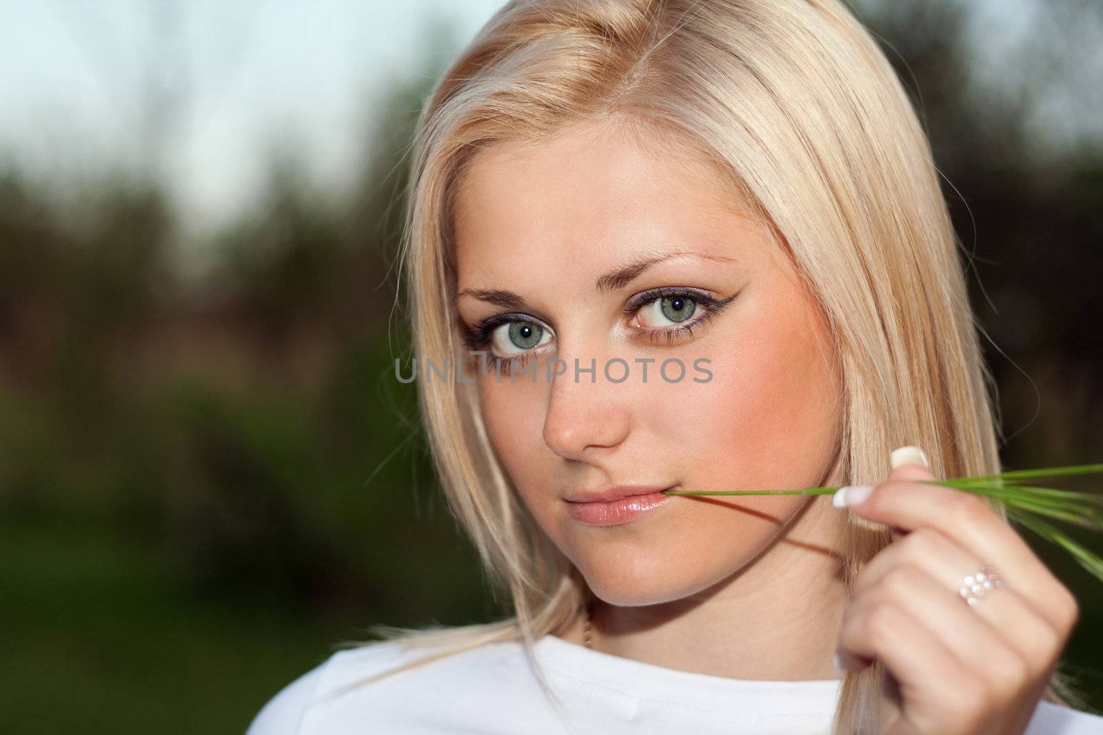 Young blonde with a sprig in the mouth