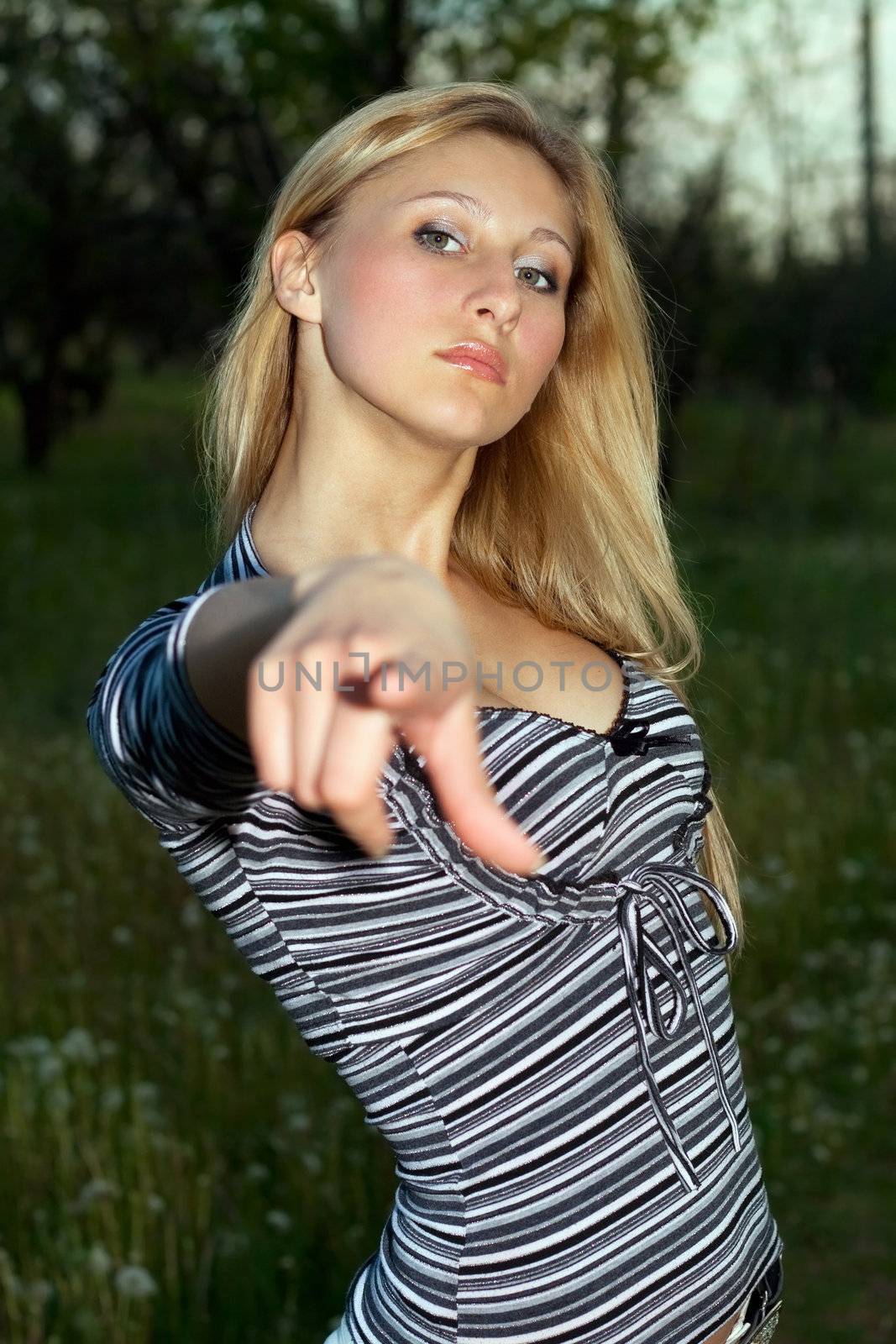 Portrait of young beautiful blonde pointing finger