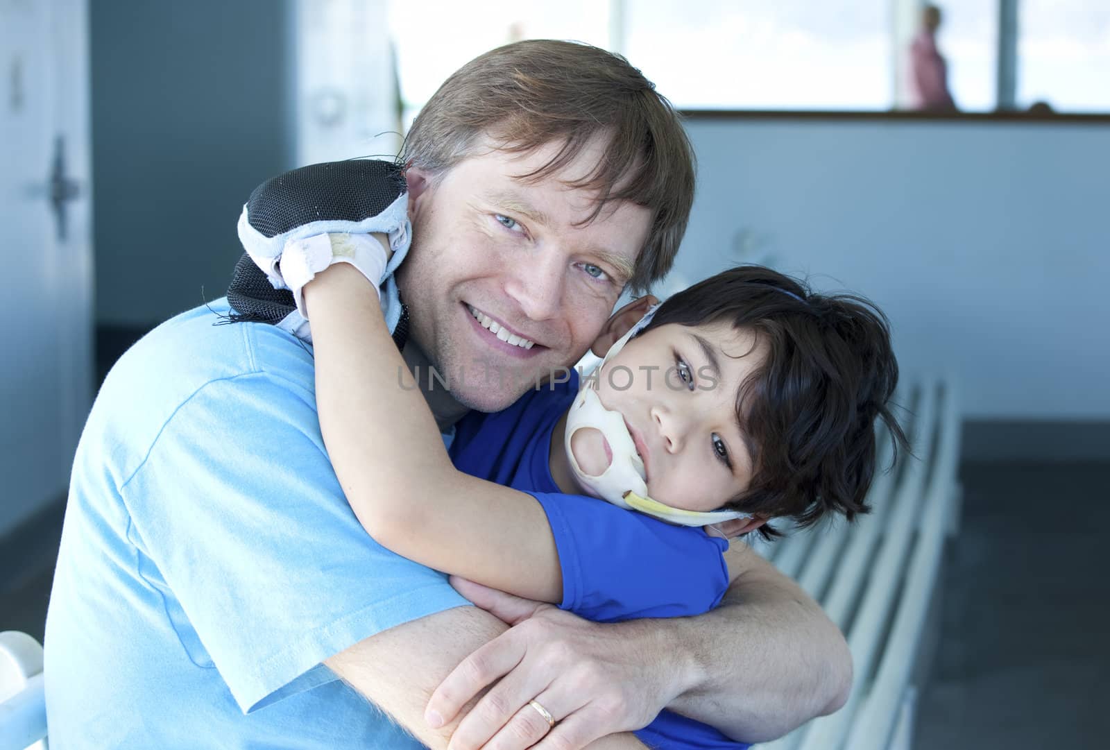 Disabled boy giving father a big hug by jarenwicklund