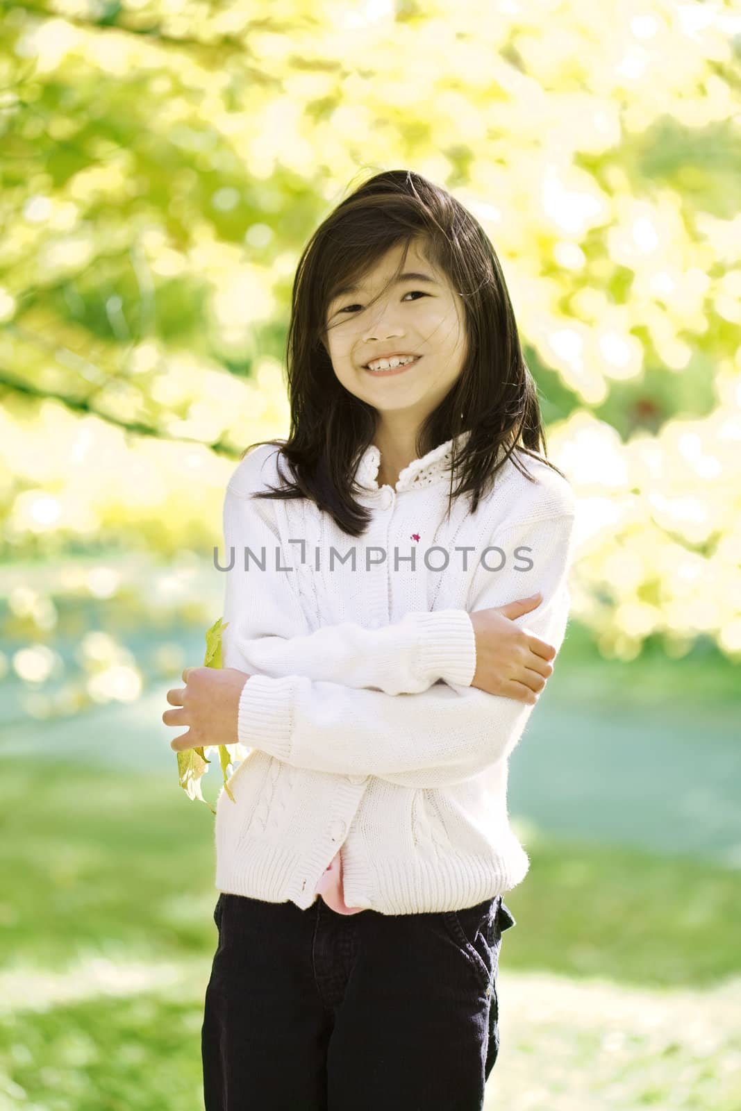 Little biracial asian girl standing amongst bright autumn leaves by jarenwicklund