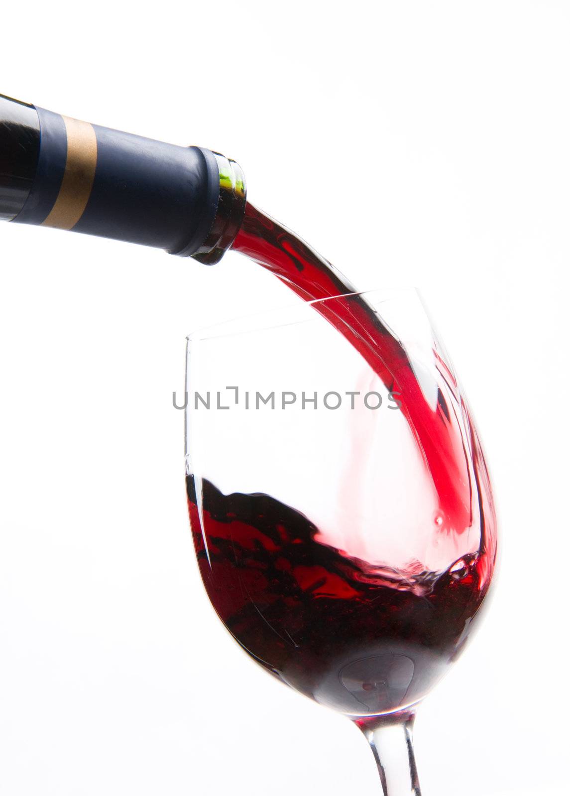 Red Wine flows strong into a wine glass