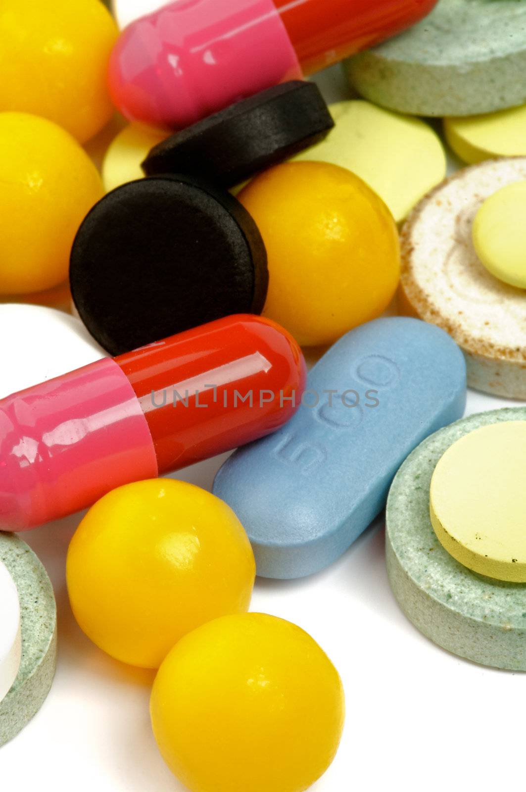 Heap of Various Colored Pills and Vitamin Pills closeup on white background