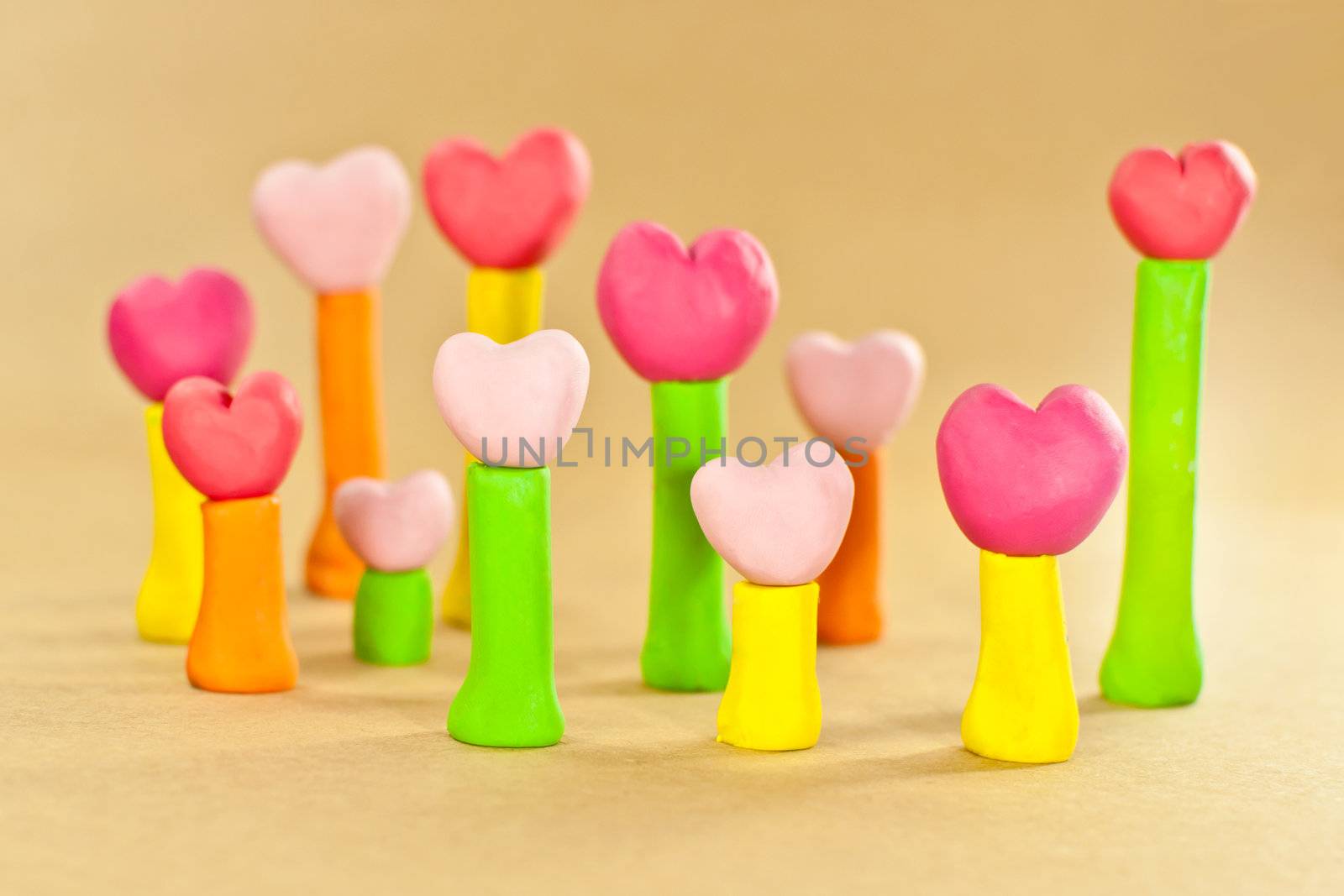 group of sweet color heart on post made from plasticine on brown paper background