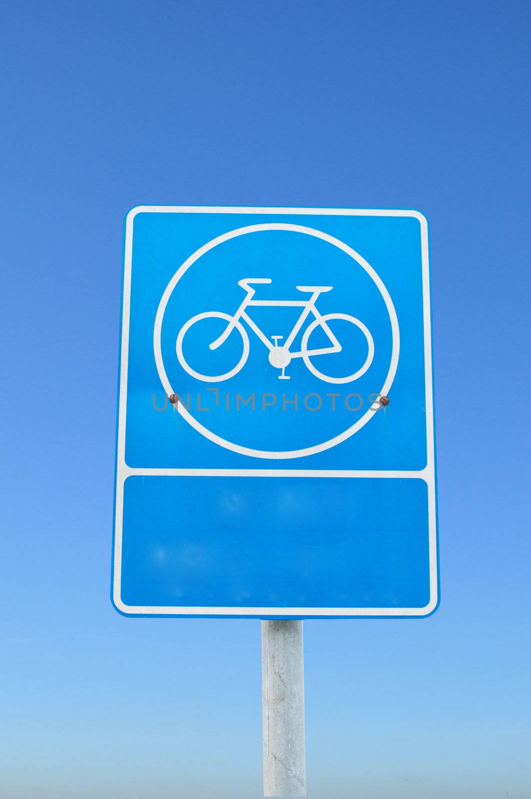 Blue parking bicycle sign on blue sky background.