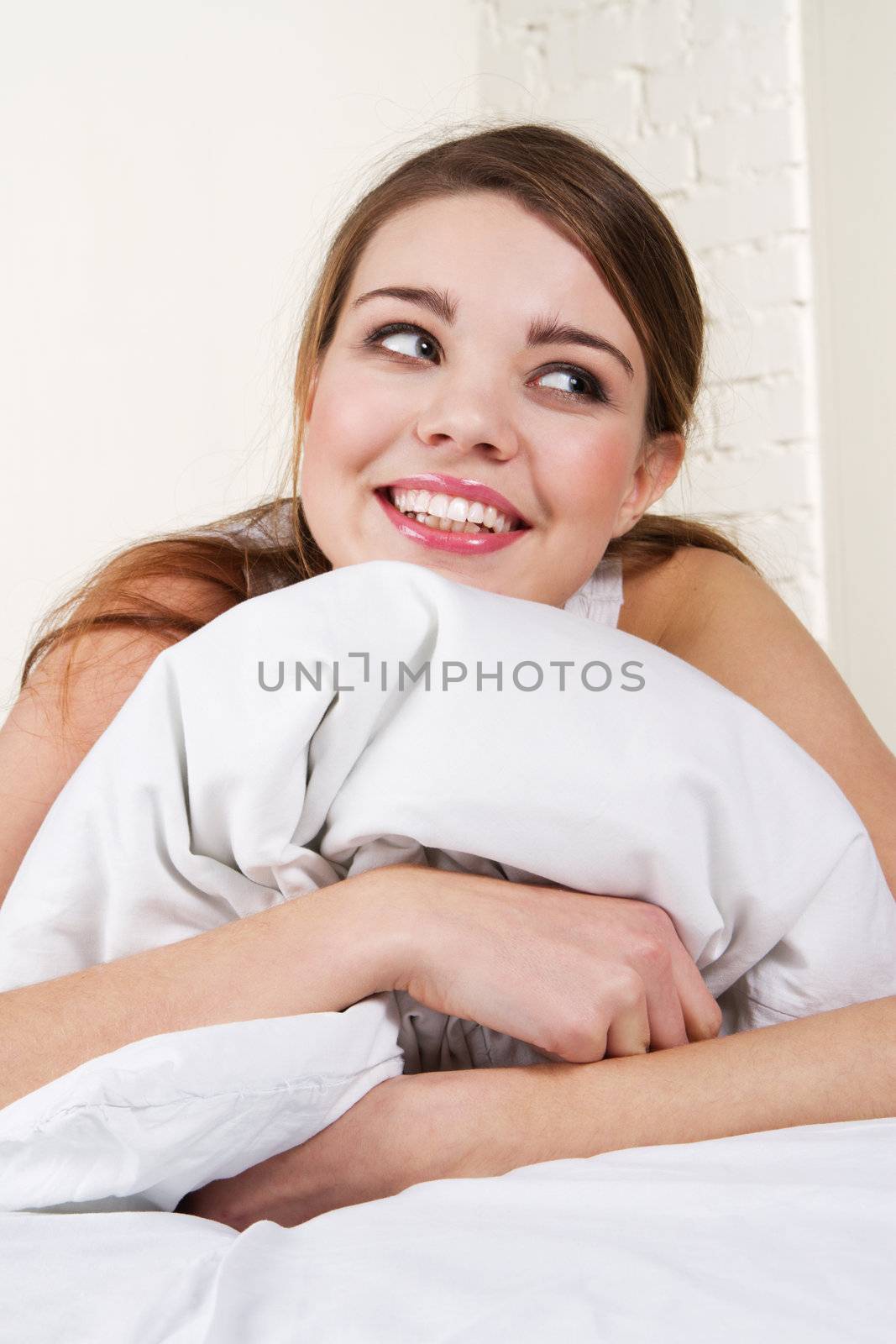 Beautiful happy girl lying in bed
