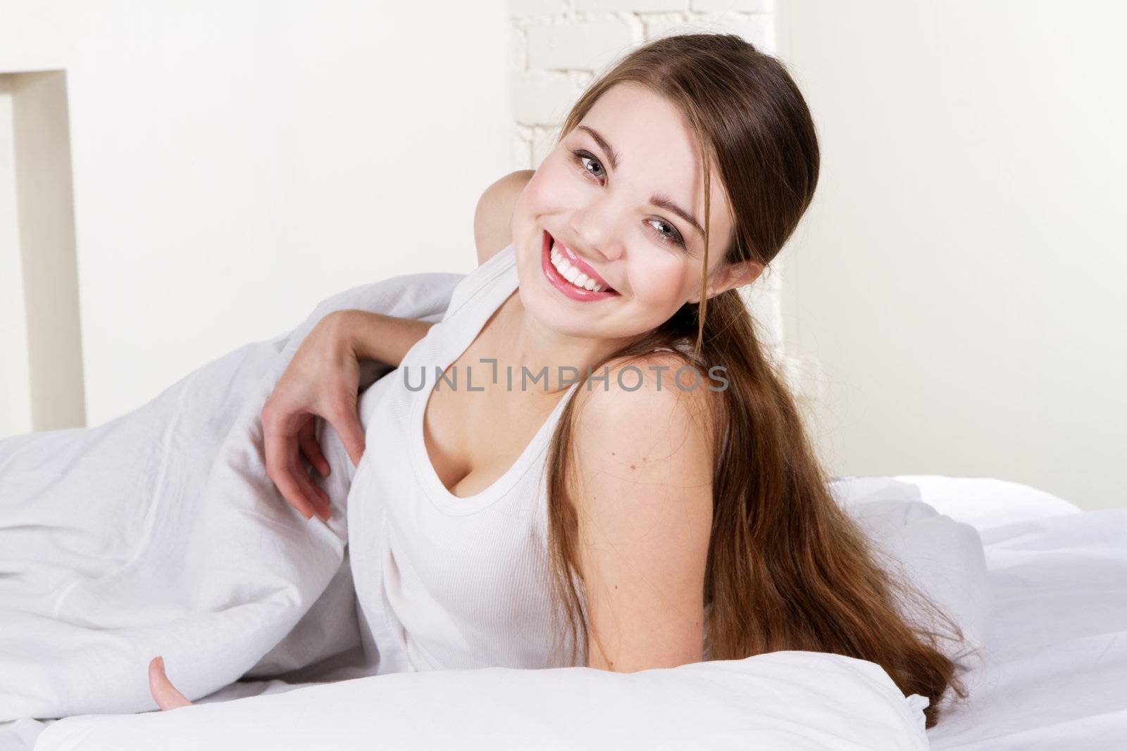 Young beautiful woman lying in bed 