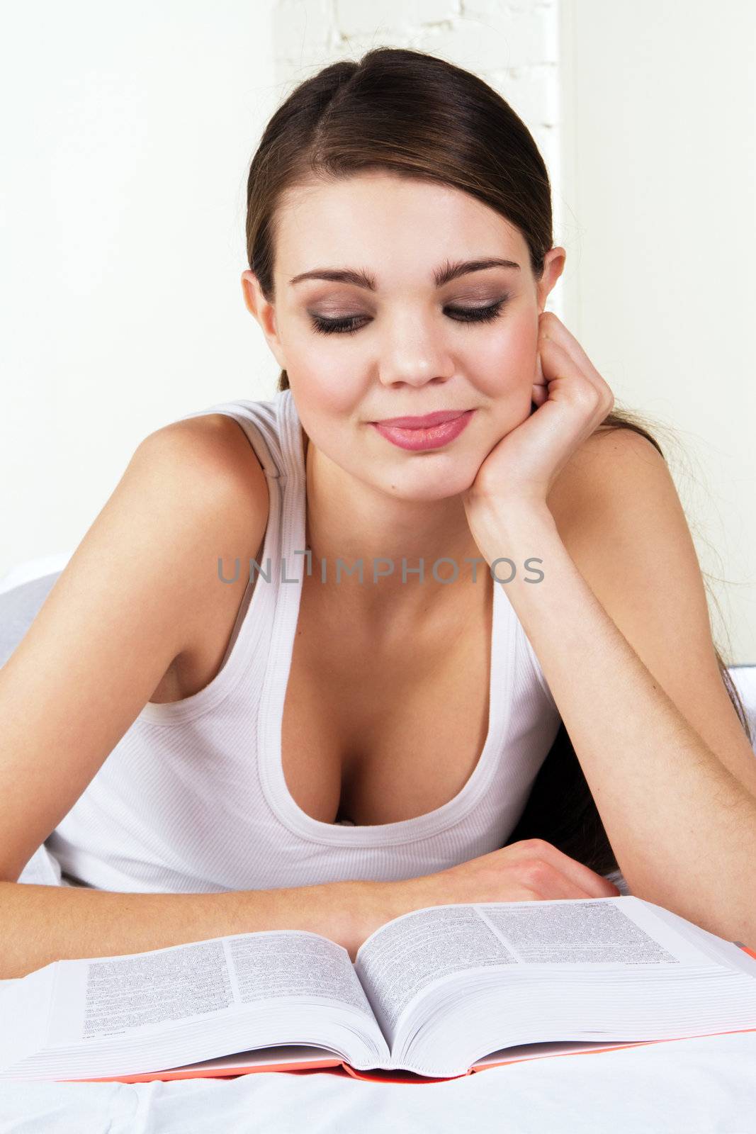 Young beautiful woman reading a book by Gdolgikh