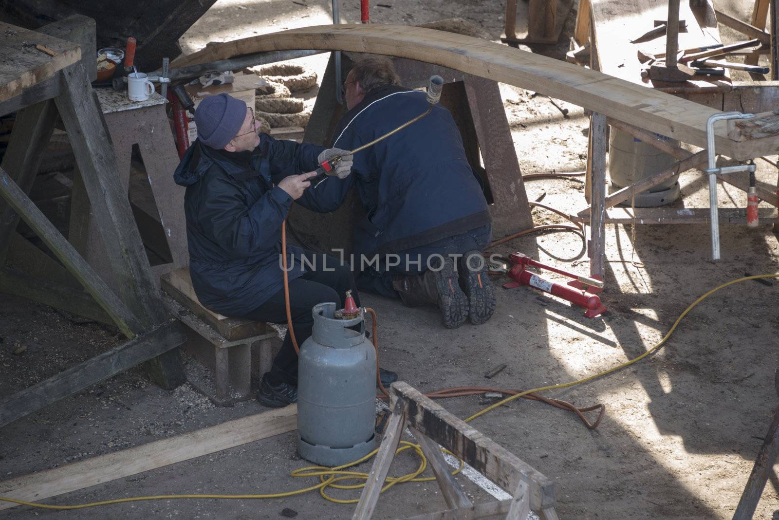 HELLEVOETSLUIS,HOLLAND-AUGUST 31:Unidentified people bending wood in the dry dock for renovation of russian frigat,on August 31,2012 in Hellevoetsluis,Holland.This renovation is only once in 13 years.