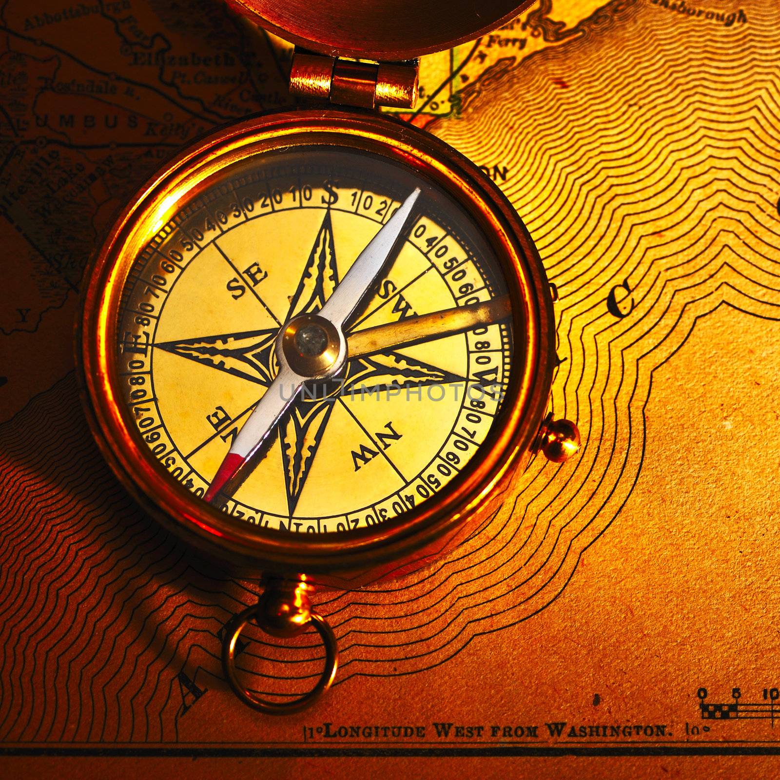 Antique brass compass over old paper background