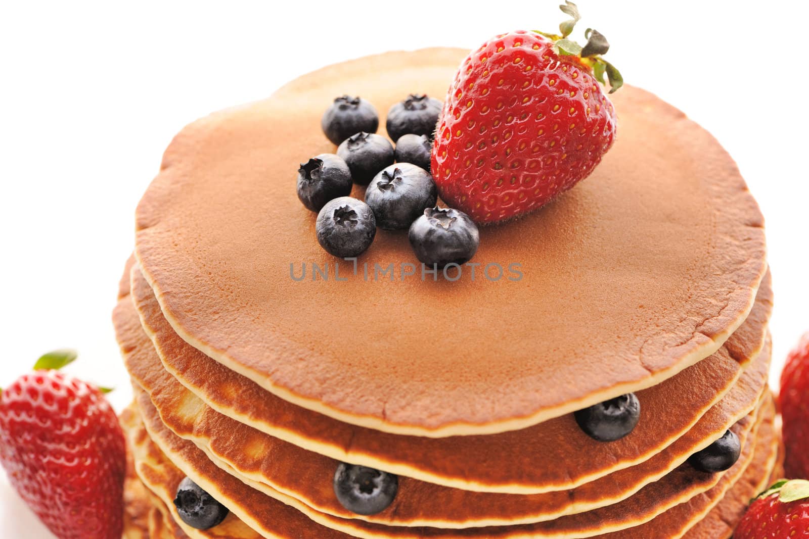 Delicious freshly prepared pancakes with strawberry and blueberries isolated on white
