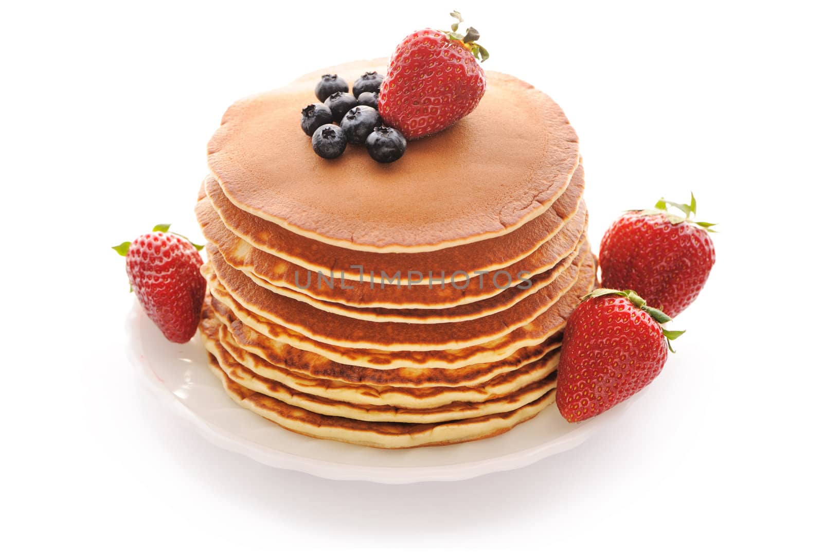 Delicious freshly prepared pancakes with strawberry and blueberries isolated on white
